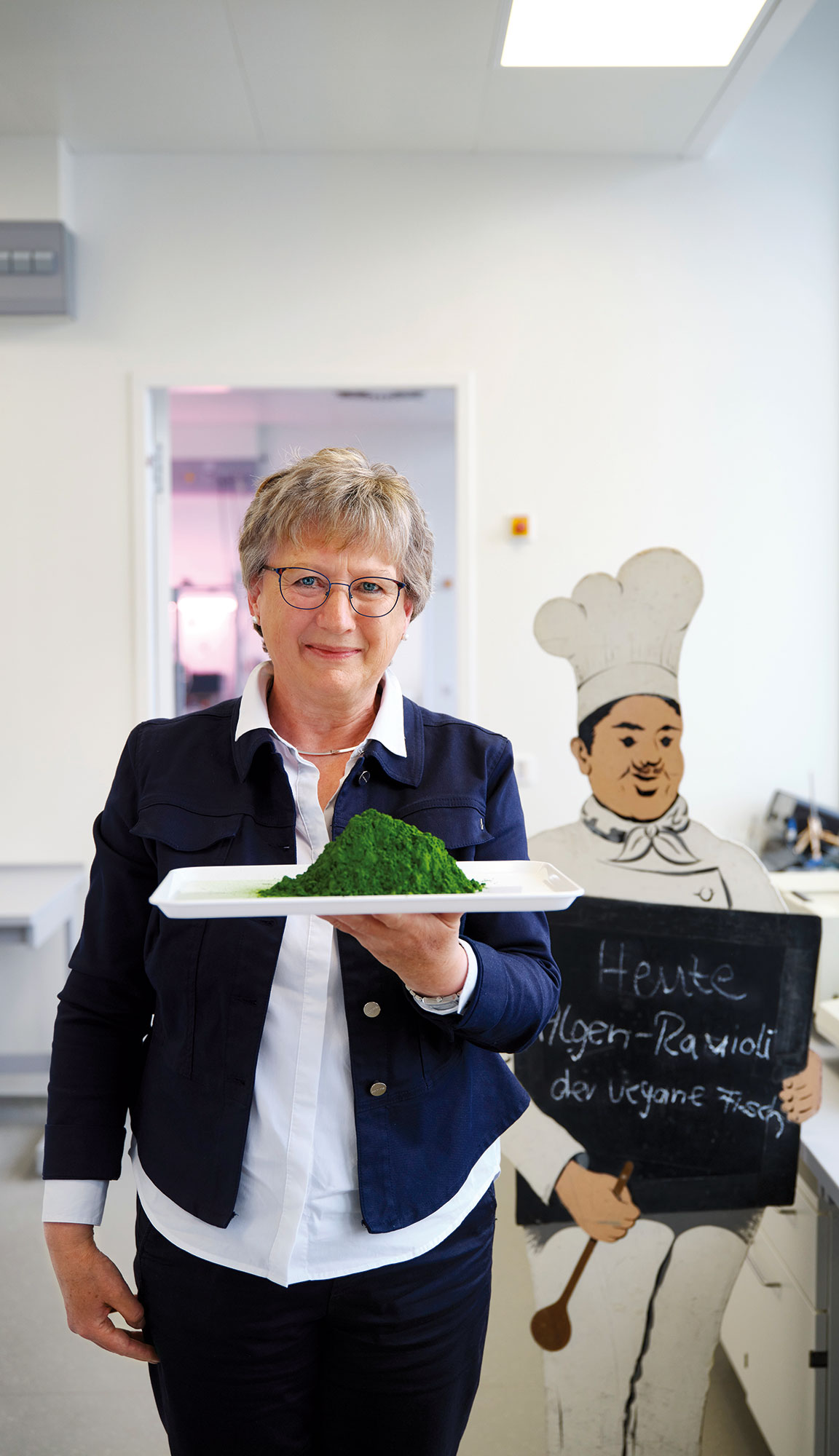 Dr. Ulrike Schmid-Staiger vom Fraunhofer IGB hält einen Teller mit einem Pulver aus Mikroalgen in der Hand.