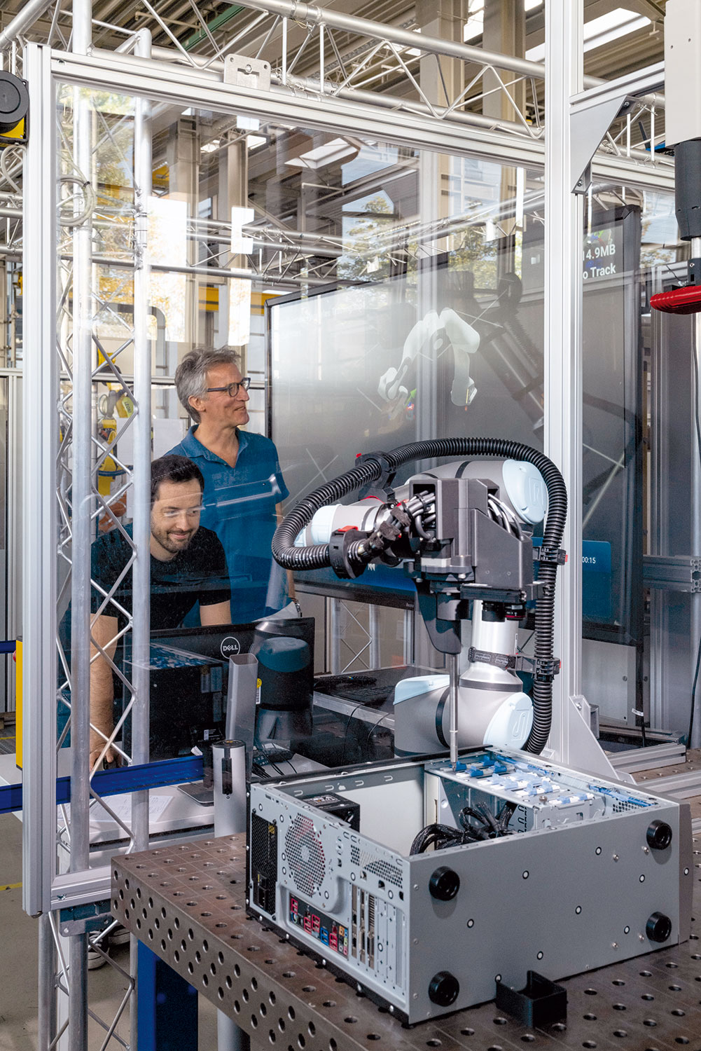 Prof. Elkmann und Magnus Hanses stehen in einer Konstruktionshalle vor einem Produktions-Roboter.