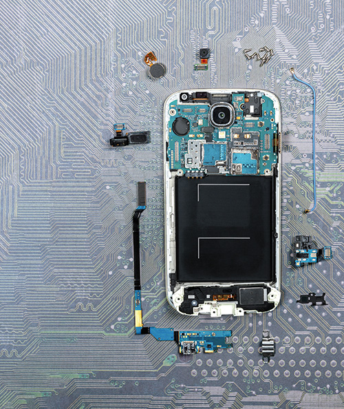 cell phone lies on a circuit board and is broken down into individual parts