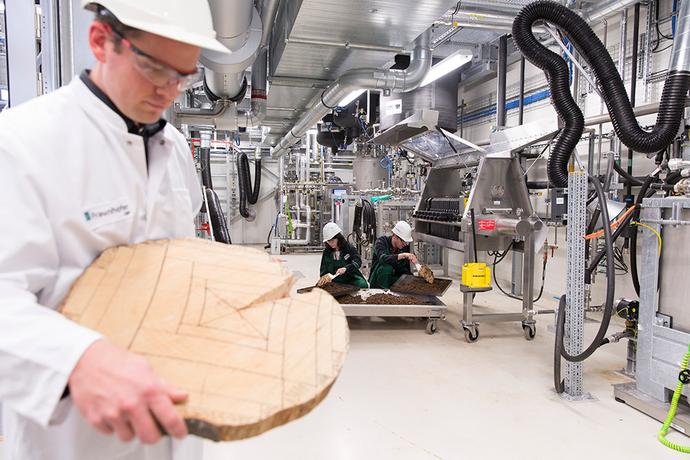 Dr. Moritz Leschinsky mit Muster zur Holznutzung aus Abfällen vom Sägewerk.