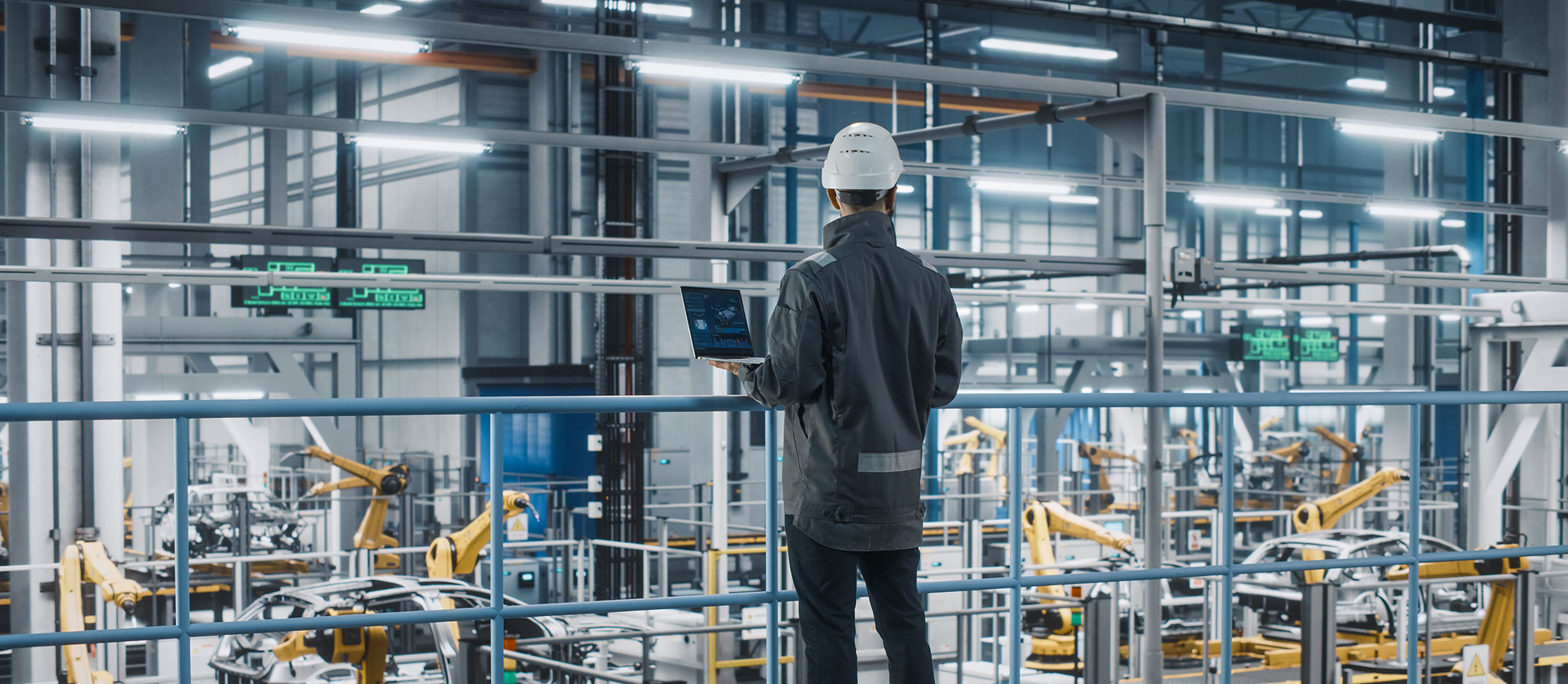 Autofabrikingenieur in Arbeitsuniform mit Laptop-Computer. 