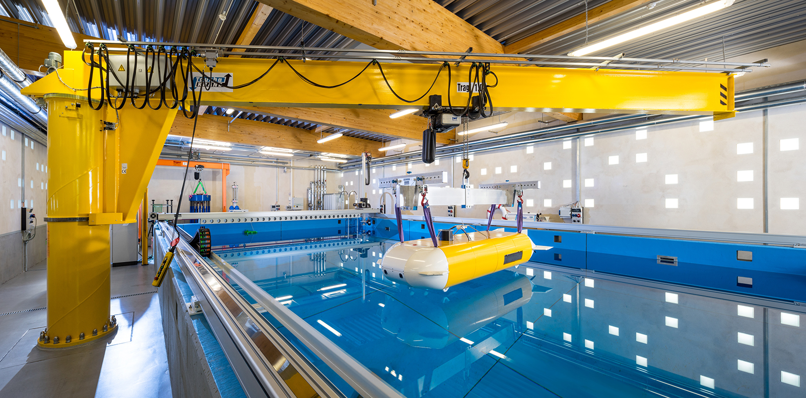 The underwater vehicle suspended above the maritime systems research platform with its slewing crane, portal system and (in the background on the left) pressure chamber.