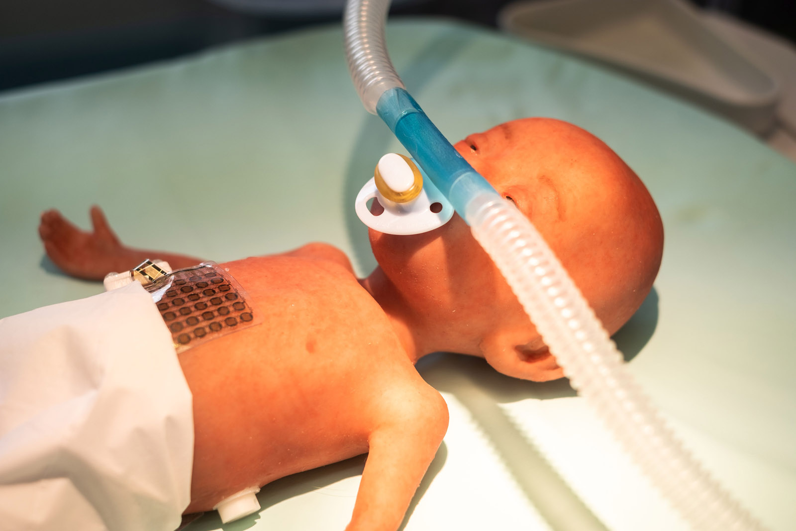 Demonstrator: Sensor film and nasal prong with integrated miniature aerosol valve on a preterm infant training dummy. 