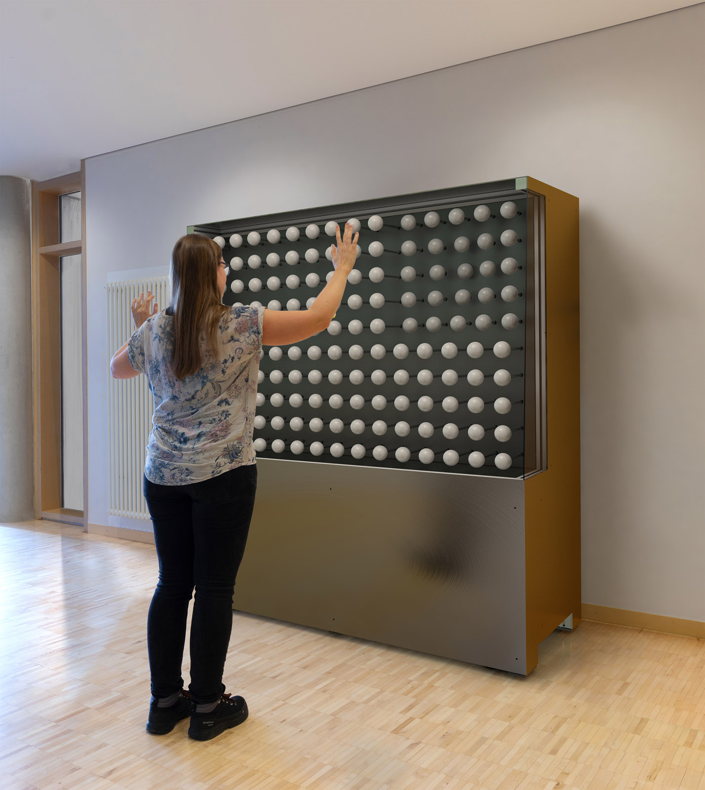 The spheres respond instantaneously to the movements of the person standing in front of the wall.