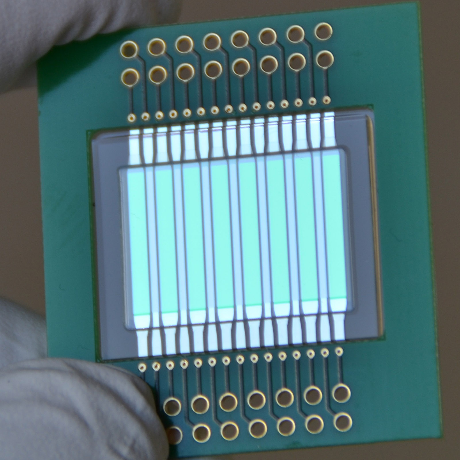 Chip with integrated light source and light detector for analyzing contaminants in milk.