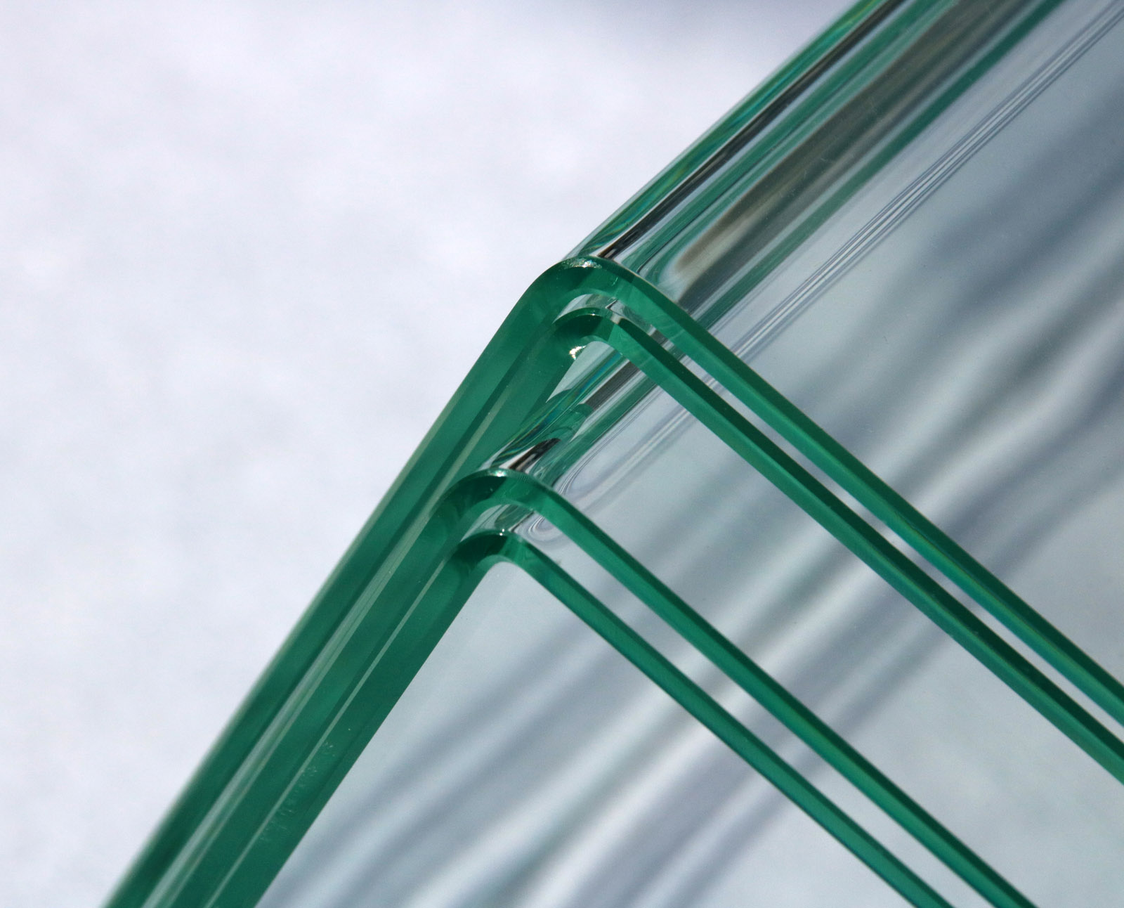 Using the new laser-based glass-bending process, it is possible to achieve precisely defined and extremely small bend radii, so that even laminated safety glass can be bent around a corner. The sheets of glass in the image are three millimeters thick.