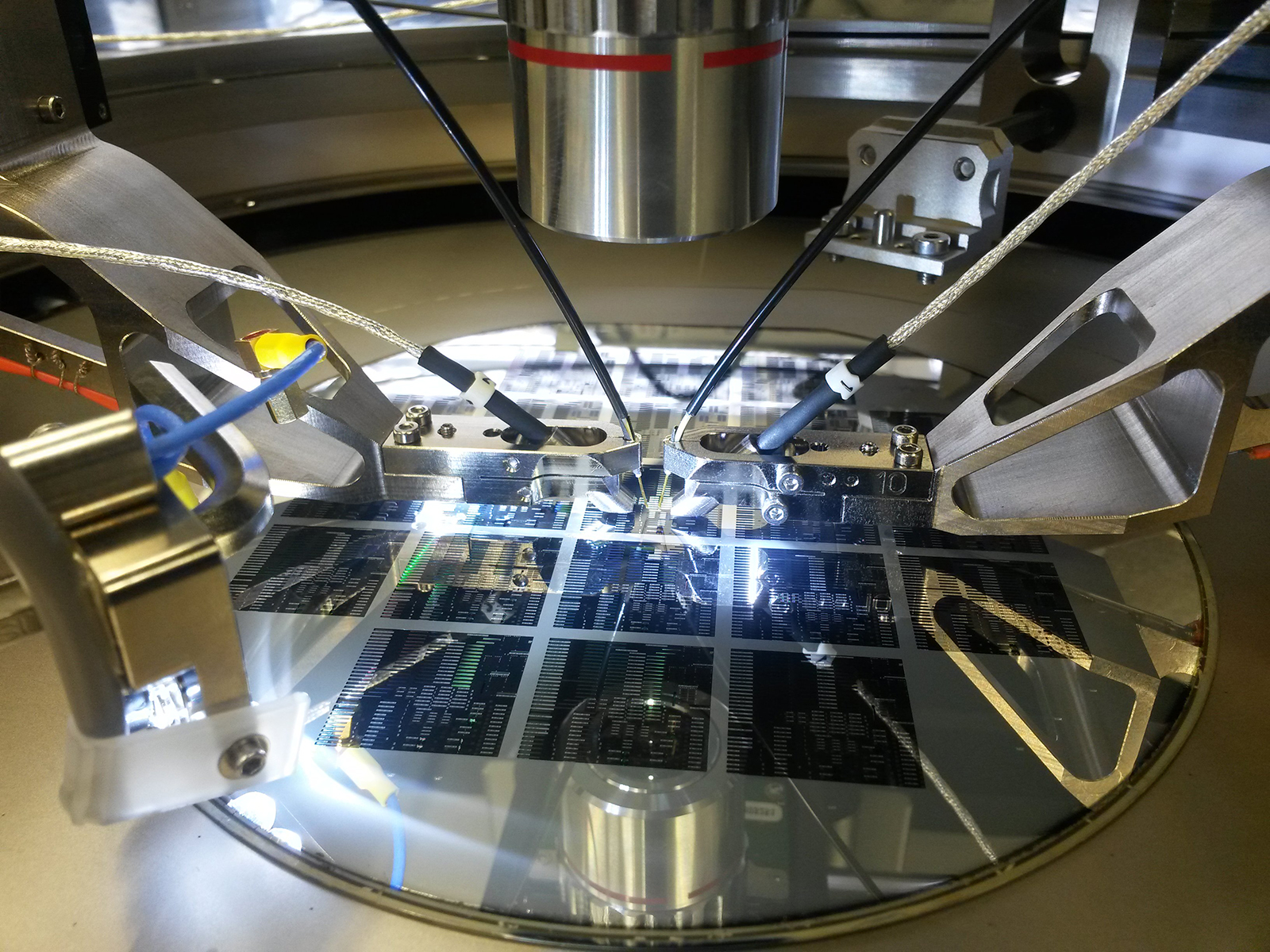 Measurement setup with wafer prober, optical fiber probes and wafer with test structures.