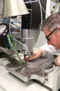 Udo Eckert, Group Leader Microsystems Manufactur-ing & Technical from the Functional Surfaces and Micromanufacturing department at Fraunhofer IWU, tests the finishing of a milled tool to be used in bipolar plate production for fuel cells at the micromachining center of Fraunhofer IWU.