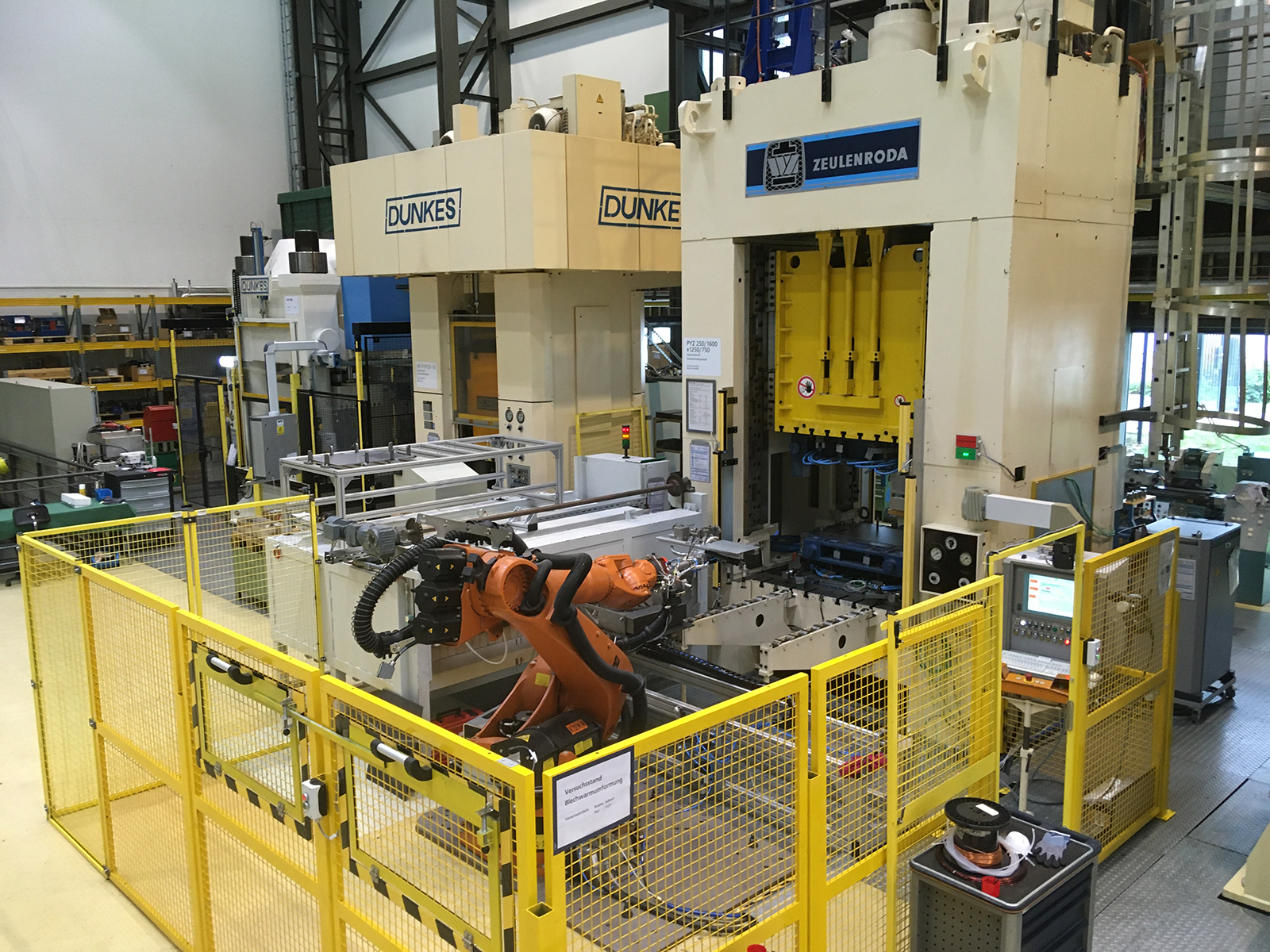 Test rig for hot sheet metal forming at Fraunhofer IWU, including oven, press, and robot.