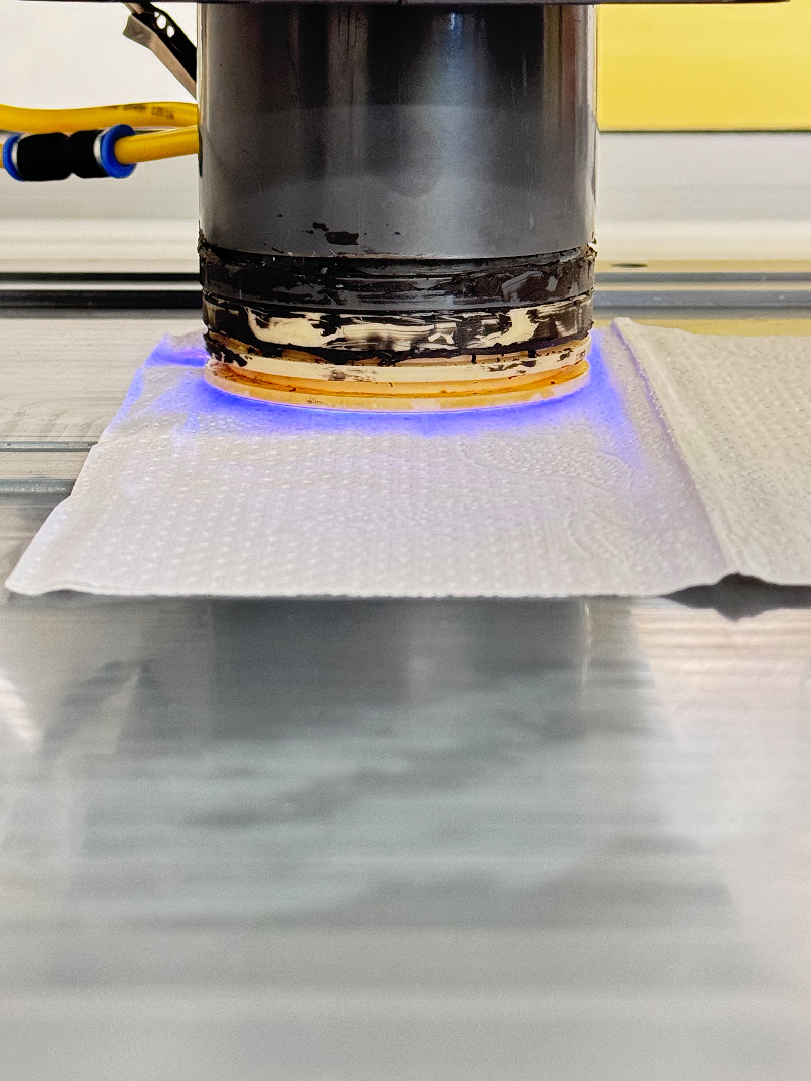 Die Plasmaquelle wird nah an die Papieroberfläche herangeführt. Zu sehen ist die direkte Interaktion des Plasmas mit dem Papier.