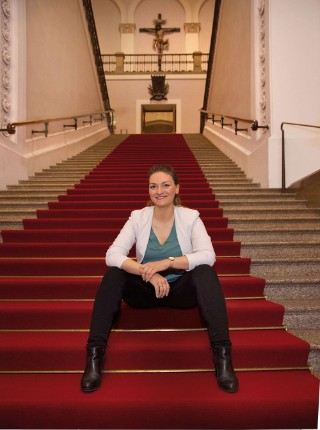 Judith Gerlach, Bayerische Staatsministerin für Digitales, sitzend auf der Treppe im Bayerischen Landtag