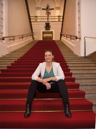 Judith Gerlach, Bayerische Staatsministerin für Digitales, sitzend auf der Treppe im Bayerischen Landtag