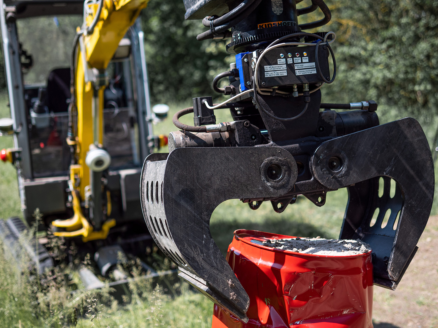 IOSB.BoB, an autonomous excavator, grabs a drum.